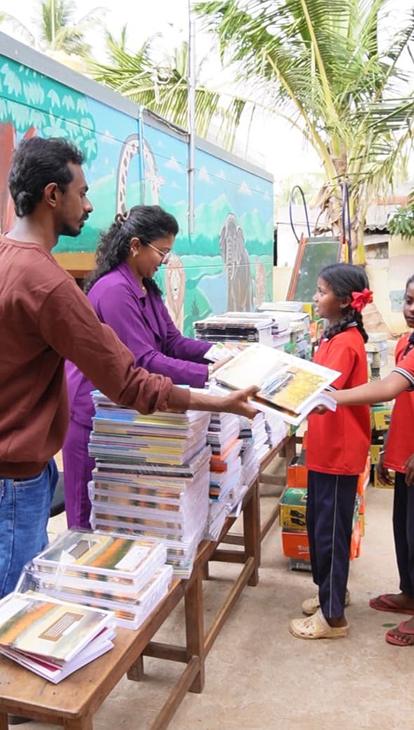 Volunteers handing textbooks to a school student